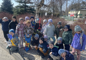 Grupa Motylki pozuje do zdjęcia pod brzozą na terenie przedszkola.
