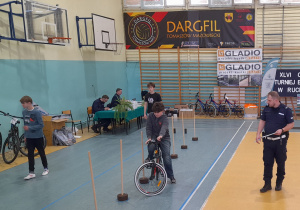 Uczeń pokonuje na rowerze slalom.