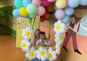 Chłopiec z grupy Motylki wraz z mamą w balonowej fotobudce.