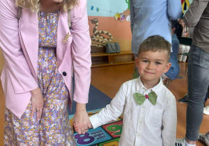 Chłopiec z grupy Motylki z mamą podczas uroczystości przedszkolnej podczas święta rodziców.