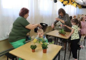 Mamy z dziećmi wykonują kompozycję " Las w szkle".