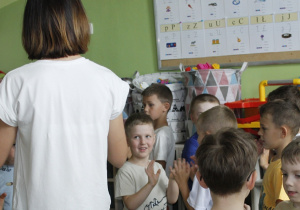 Wychowawczyni grupy ,,Misie” prowadzi zabawę dla dzieci w przerwie między czytanymi wierszami.