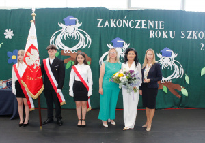 Dyrektor szkoły z wręczonymi kwiatami od zastępcy wójta Gminy Rzeczyca oraz przewodniczącej Rady Gminy.