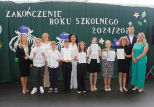 Uczniowie klasy 4, którzy uzyskali wysokie wyniki w nauce, wraz z wychowawcą, panią dyrektor i przedstawicielami organu prowadzącego szkołę.