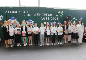 Wyróżnieni uczniowie klasy 5 wraz z wychowawcą, panią dyrektor, zastępcą wójta gminy, przewodniczącą Rady Gminy oraz panią inspektor ds. oświaty.