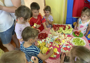 Dzieci robią kolorowe szaszłyki.