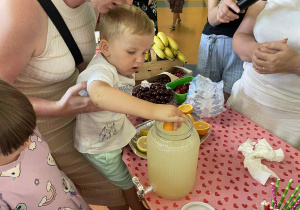 Dziecko wyciska sok z pomarańczy do lemoniady.