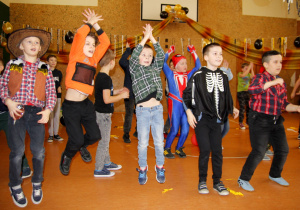 zdjęcie przedstawia grupę tańczących chłopców w karnawałowych przebraniach