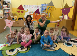 Grupowe zdjęcie dzieci z grupy Słoneczka z Panią psycholog i wychowawcą i emotikonami.