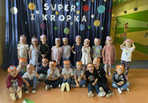 Zdjęcie grupowe dzieci z grupy Szkraby w Dniu Kropki prezentują korony w kropki.