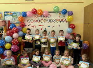 Grupa żabki z dyplomami z okazji dnia przedszkolaka.