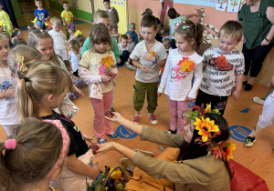 Pani Jesień wręcza dzieciom z grupy Zuchy jesienne owoce.