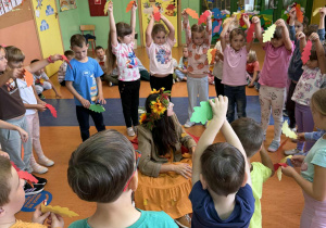 Dzieci z grupy Skoczki recytują pani Jesieni wiersz trzymając w dłoniach kolorowe jesienne liście.