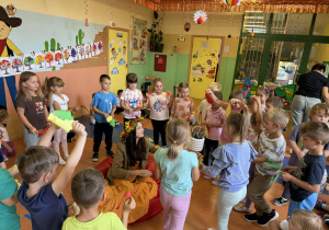 Pani Jesień wręcza grupie Skoczki dar jesieni - doniczkę z wrzosem.