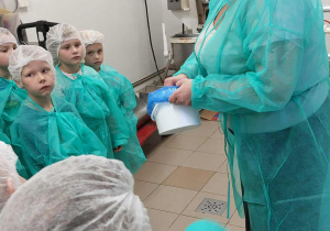 Przewodniczka opowiada dzieciom jakich składników używamy do produkcji krówek.