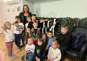 Chłopcy i dziewczynki z grupy Żabki na tle modelu porcelanowej małej krówki.