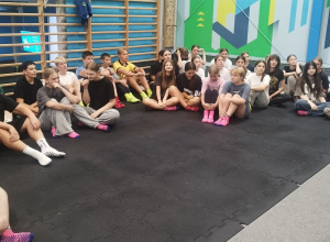 Uczniowie klas 7a oraz 8a w parku trampolin, słuchający instruktora.