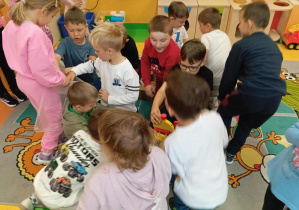 Chłopcy z grupy Skoczki rozpakowują prezent z okazji Dnia Chłopaka.