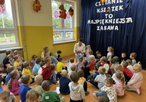 Pani Karolina Tomasik czyta książkę dzieciom z grupy Kamyczki, Szkraby i Promyczki w Dniu Głośnego Czytania.