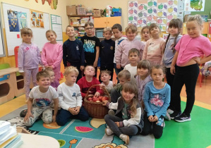 Zdjęcie grupowe dzieci z grupy Skoczki z koszem jabłek w Dniu Jabłka.