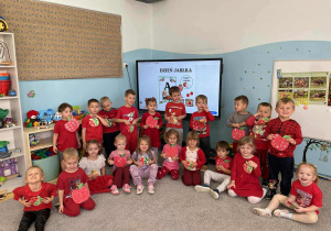 Zdjęcie grupowe dzieci z grupy Szkraby w dłoniach trzymają własnoręcznie wyklejone jabłka.