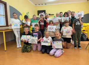 Grupa uczniów przebywających na świetlicy prezentująca prace z Okazji Międzynarodowego Dnia Kropki.