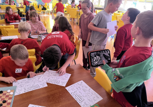 Uczniowie rozmawiają z kolegami i umieszczają imiona osób na karcie na której są umieszczone pytania w celu lepszego poznania się.