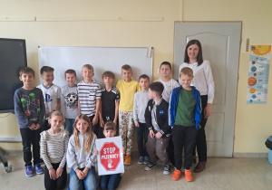 Klasa III z pedagogiem specjalnym i plakatem STOP PRZEMOCY.