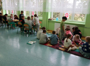Korytarz szkolny podczas długiej przerwy z dziećmi grającymi w planszówki.