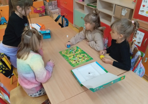 Cztery dziewczynki z grupy Skoczki grają w grę planszową Grzybobranie.