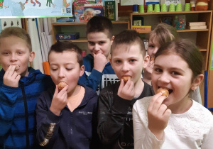 uczniowie klasy III zajadają pączki
