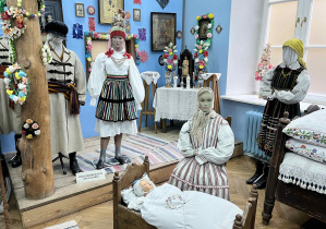 Ekspozycja etnograficzna, przedstawiająca izbę – pięknie przystrojona, łóżko przykryte kilimkami i poduszkami w poszewkach bogato ozdobionych haftami, skrzynia wiana pełna zapasek, wełniaków, koszul.