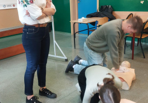 Uczniowie wykonują RKO pod okiem lekarza.