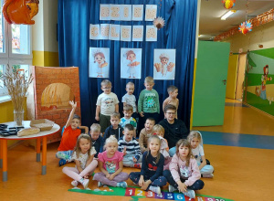Zdjęcie grupowe "Zuchów" na tle dekoracji z okazji Dnia Chleba.