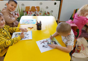 Chłopcy z grupy Zuchy kolorują kredkami prace piekarza i młyn.