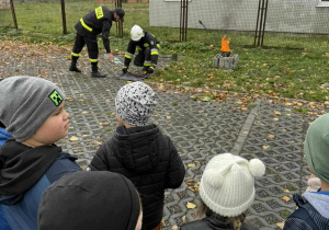 Strażacy przygotowują pokaz gaszenia płonącego oleju.