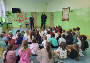 Uczniowie klas 1-3 słuchają pogadanki prowadzonej przez policjantów.