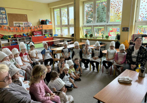 Dzieci z dwóch grup przedszkolnych oglądają film edukacyjny o tym jak powstaje chleb.