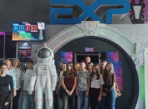 Uczniowie z opiekunami przy skafandrze kosmonauty przed wejściem do Laser Areny.