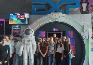 Uczniowie z opiekunami przy skafandrze kosmonauty przed wejściem do Laser Areny.