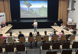 Pani Dyrektor GOK opowiada o książkach z serii Biuro Detektywistyczne Lassego i Mai. Uczniowie znajdują się w sali widowiskowej GOK w Rzeczycy.