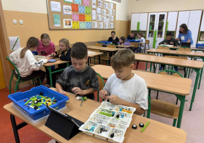 Uczniowie pracują nad projektami robotów.
