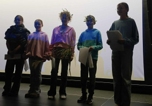 Uczniowie odgrywają scenkę na podstawie mitu ,,Demeter i Kora” na scenie sali widowiskowej GOK W Rzeczycy.