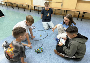 Uczniowie doprowadzili do starcia sumobotów. Uczniowie obserwują jak zachowują się sumoboty.