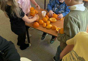 Dzieci układają wieże z połówek pomarańczy.