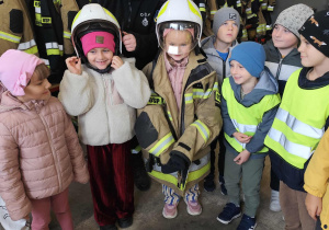 Skoczki w hełmach strażackich.