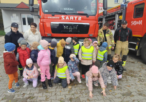 Skoczki - zdjęcie grupowe ze Strażakami przed wozem strażackim.