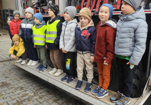 Chłopcy Skoczki przed pojazdem strażackim.