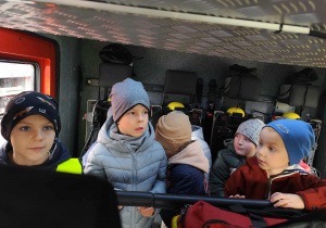 Chłopcy wewnątrz pojazdu strażackiego.