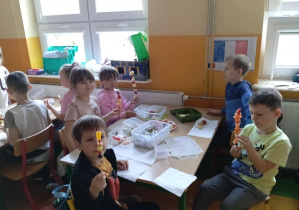 Dzieci z grupy Skoczki przy stoliku prezentują owocowe szaszłyki.